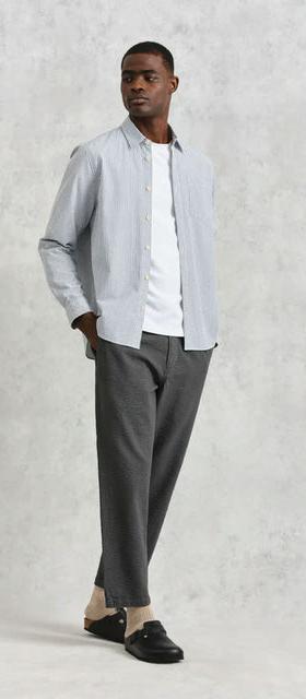 A man wearing Wax shelly shirt navy seersucker stripe