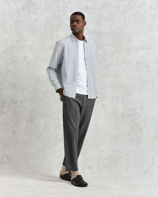A man wearing Wax shelly shirt navy seersucker stripe