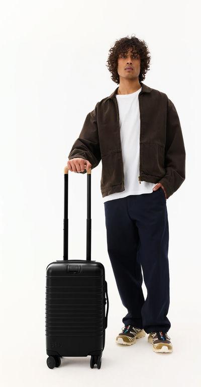 A man with BÉIS Travel the small carry-on roller luggage in black