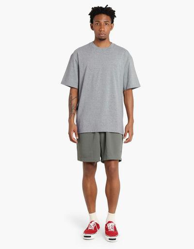 A man wearing Madness grey madness logo tee