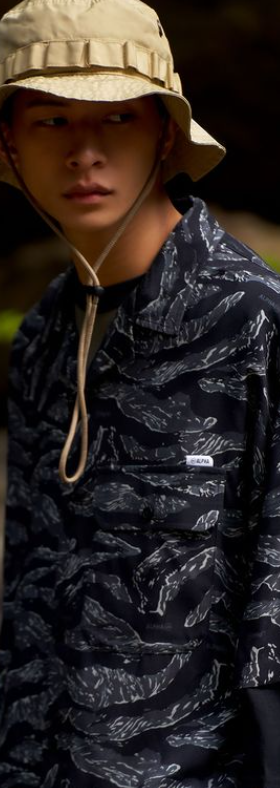 A man wearing Double-park army hawaii shirt featuring a camouflage color palette