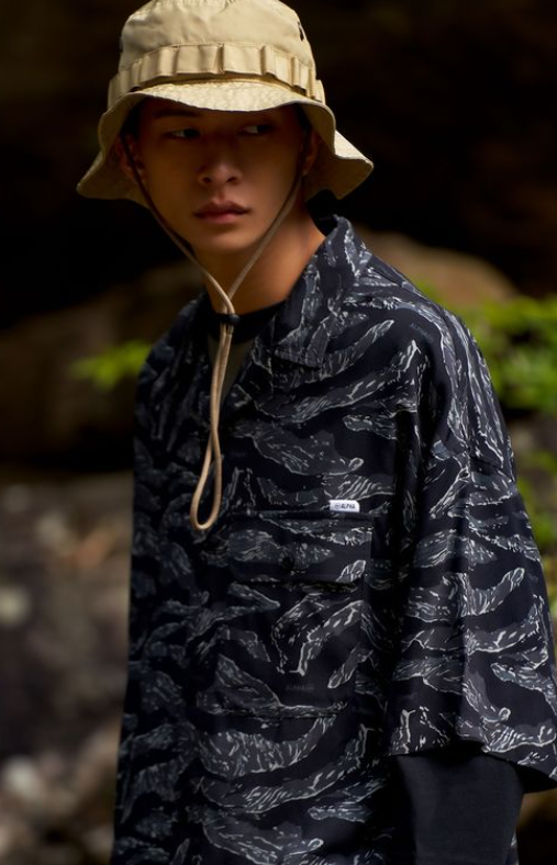 A man wearing Double-park army hawaii shirt featuring a camouflage color palette