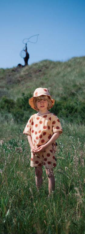 A kid wearing Daily Brat Baby very berry towel t-shirt sand