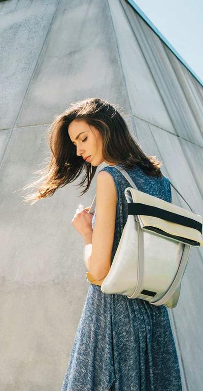 A woman carrying Maria Maleta lisbon backpack silver