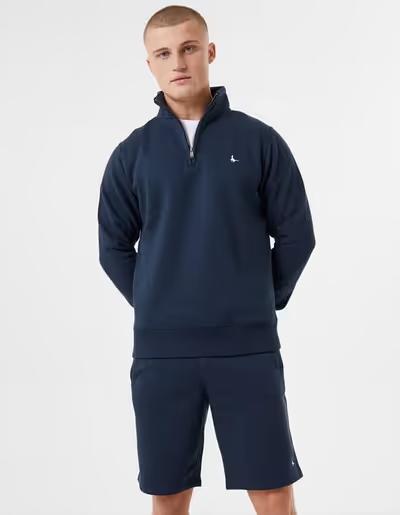 A man wearing Jack Wills navy color barchester quarter zip sweatshirt