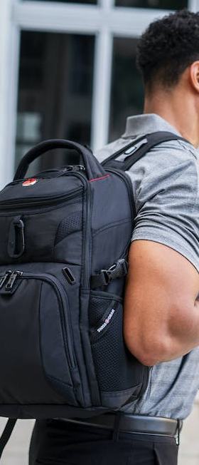 A man wearing a Swiss Gear backpack in black
