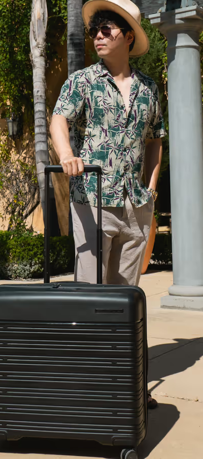 A man holding a Samsonite black suitcase for traveling