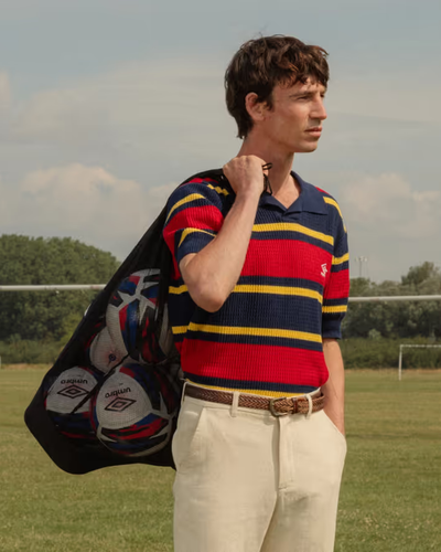 A man wearing a Umbro slacks and striped short-sleeve shirt