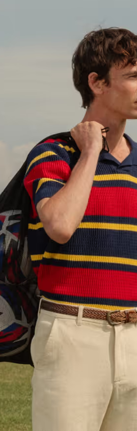 A man wearing a Umbro slacks and striped short-sleeve shirt