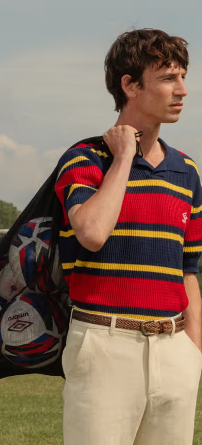 A man wearing a Umbro slacks and striped short-sleeve shirt