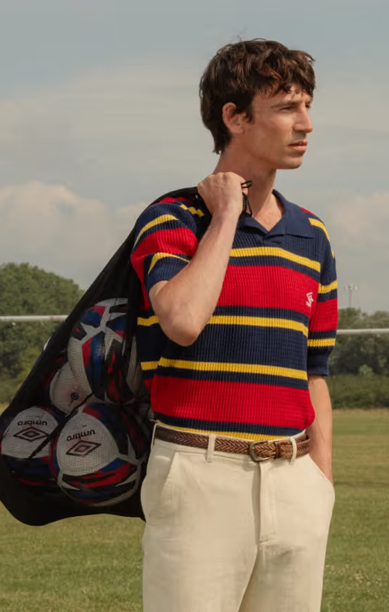 A man wearing a Umbro slacks and striped short-sleeve shirt