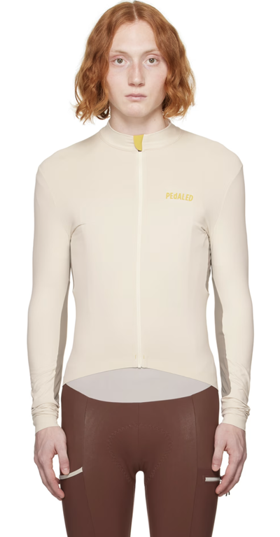 A man wearing a Pedaled cycling outfit in beige and brown