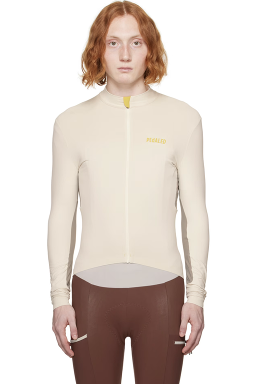 A man wearing a Pedaled cycling outfit in beige and brown