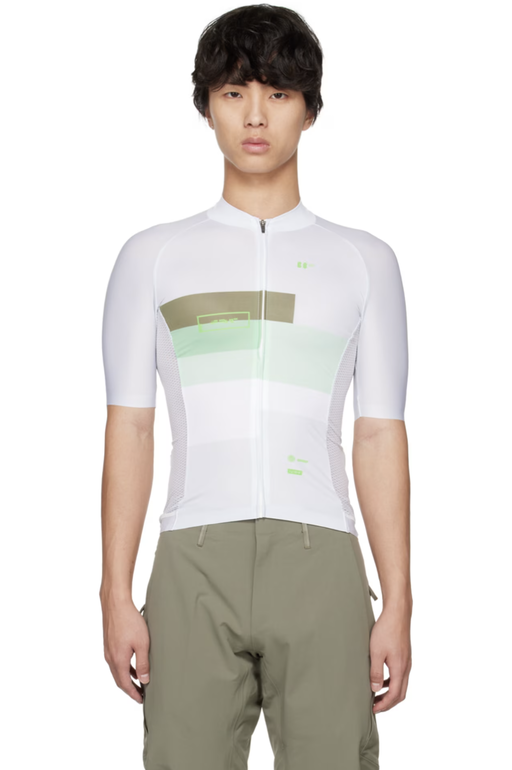 A man wearing a BBUC cycling outfit in white and green
