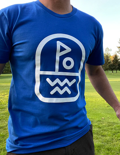 A man wearing Clinch Golf blue clinch 'flagstick' ss tee
