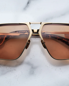 An image of Jacques Marie Mage sungalss made of titanium frame with orange lenses