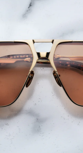 An image of Jacques Marie Mage sungalss made of titanium frame with orange lenses