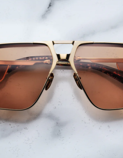 An image of Jacques Marie Mage sungalss made of titanium frame with orange lenses