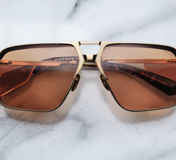 An image of Jacques Marie Mage sungalss made of titanium frame with orange lenses
