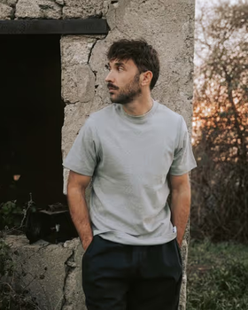 A man wearing a grey Bleu de chauffe t-shirt and navy blue pants