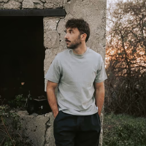 A man wearing a grey Bleu de chauffe t-shirt and navy blue pants