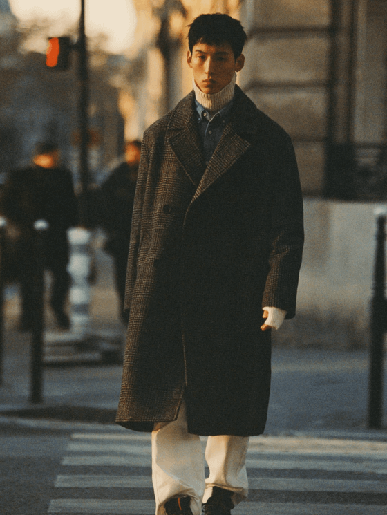 A man walking on the street wearing a Zara outfit featuring a brown jacket and beige turtleneck