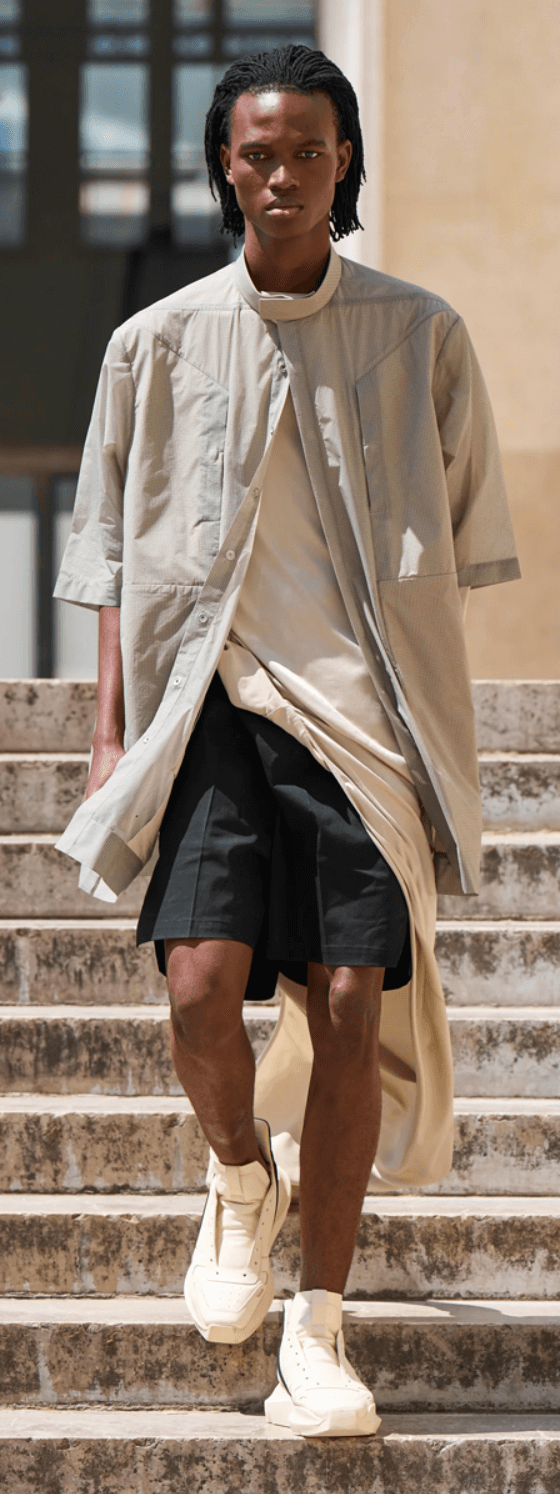 A man walking down steps on a sunny day wearing a Rick Owens outfit featuring a space grey overshirt, black shorts and shoes