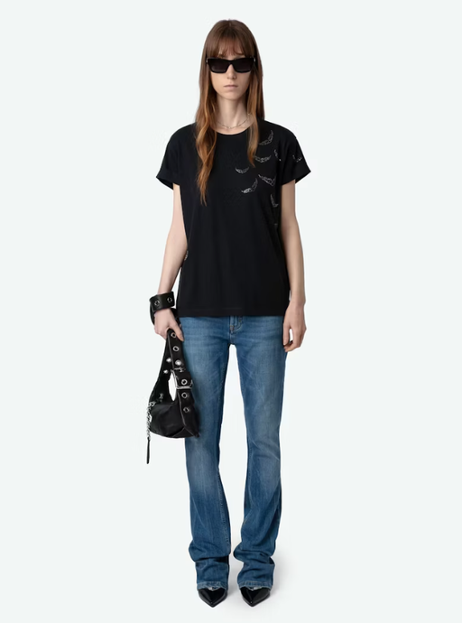 A woman wearing Zadig & Voltaire stone color anya diamante wings t-shirt