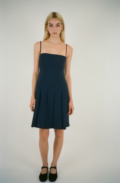 A woman wearing Sandy Liang roo dress in navy