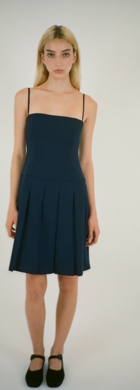 A woman wearing Sandy Liang roo dress in navy