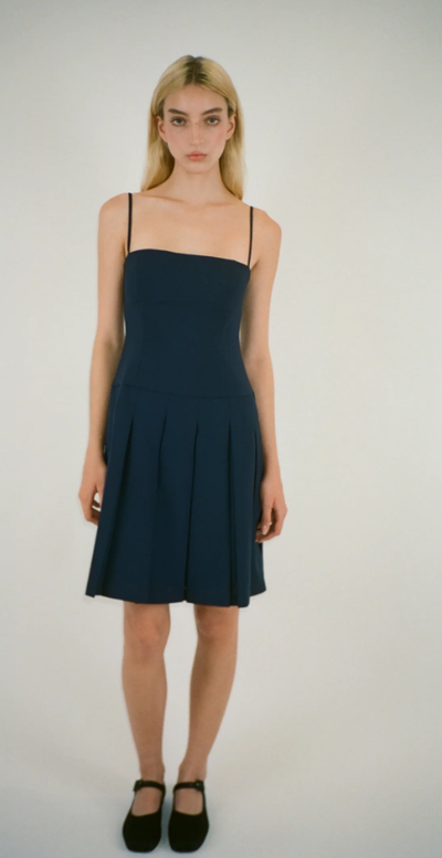 A woman wearing Sandy Liang roo dress in navy