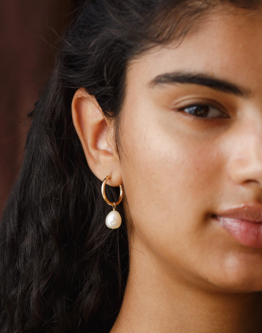 A woman wearing GLDN kana earrings