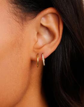 A woman wearing Gorjana classic huggie set earrings