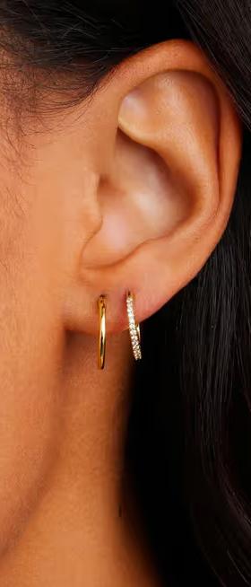 A woman wearing Gorjana classic huggie set earrings