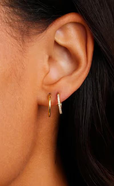 A woman wearing Gorjana classic huggie set earrings