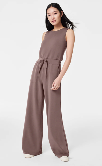A woman wearing Spanx smoke color airessentials jumpsuit
