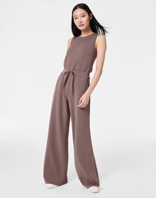 A woman wearing Spanx smoke color airessentials jumpsuit