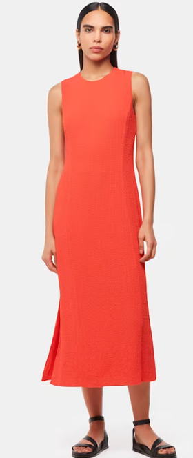 A woman wearing Whistles coral color erin texture midi dress