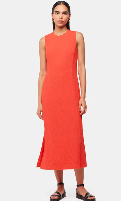 A woman wearing Whistles coral color erin texture midi dress