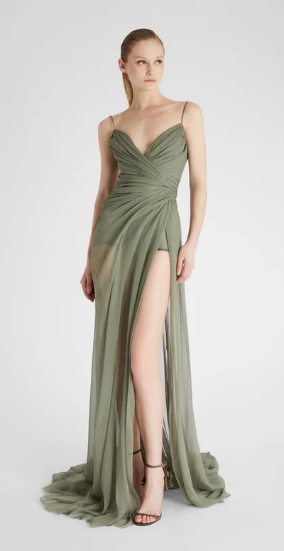 A woman wearing Ermanno Scervino green long silk dress with slit