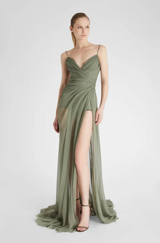 A woman wearing Ermanno Scervino green long silk dress with slit
