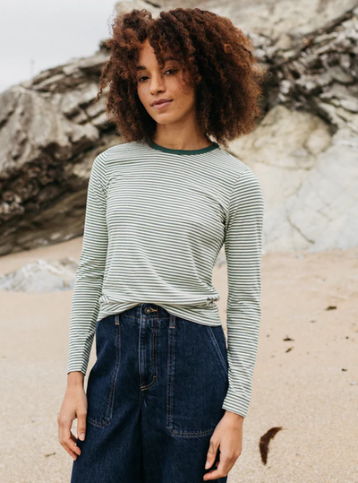 A woman wearing finisterre pine shadow/ecru/tea green women's eldon long sleeve t-shirt