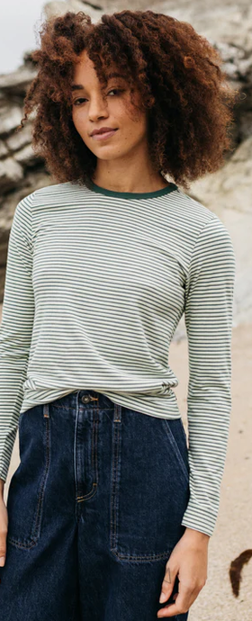 A woman wearing finisterre pine shadow/ecru/tea green women's eldon long sleeve t-shirt
