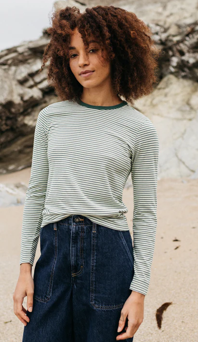 A woman wearing finisterre pine shadow/ecru/tea green women's eldon long sleeve t-shirt