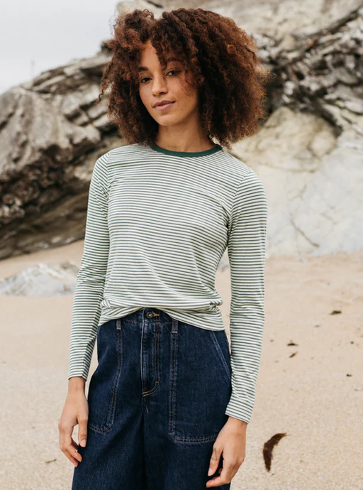 A woman wearing finisterre pine shadow/ecru/tea green women's eldon long sleeve t-shirt