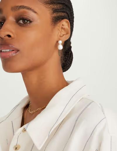 A woman wearing Mejuri bold pearl drop earrings