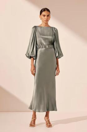 A woman wearing Shona Joy sage color la lune balloon sleeve midi dress with belt