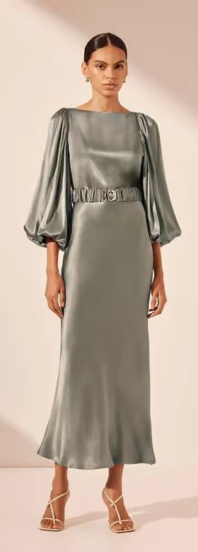 A woman wearing Shona Joy sage color la lune balloon sleeve midi dress with belt