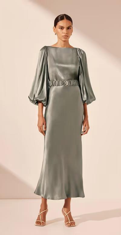 A woman wearing Shona Joy sage color la lune balloon sleeve midi dress with belt