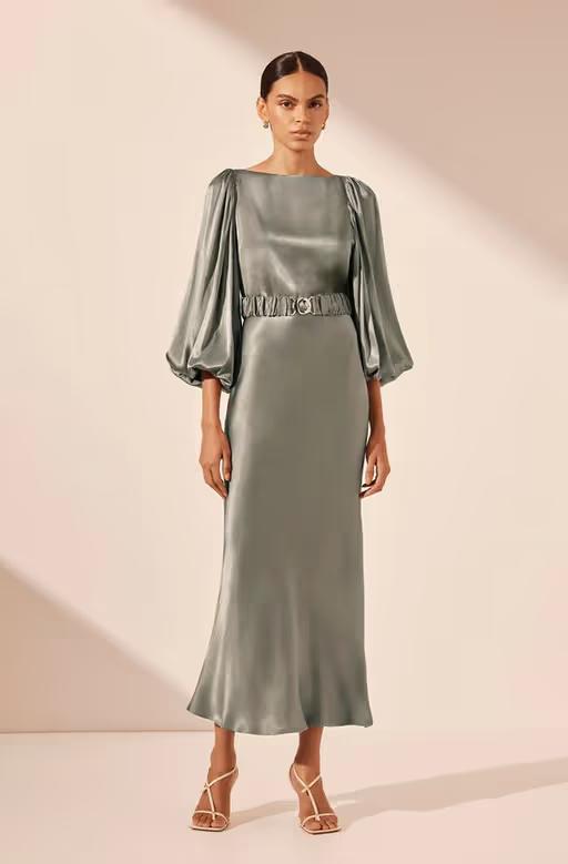 A woman wearing Shona Joy sage color la lune balloon sleeve midi dress with belt